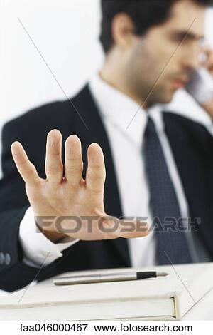 Businessman on phone call, making stop gesture with hand View Large Photo Image Stock Photo - Businessman on phone call, making stop gesture with hand. Fotosearch