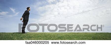 Businessman standing in grassy field with arms out, leaning forward into wind View Large Photo Image Stock Photography - Businessman standing in grassy field with arms out, leaning forward into wind. Fotosearch