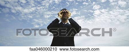 Businessman using binoculars, cloudscape in background View Large Photo Image Stock Image - Businessman using binoculars, cloudscape in background. Fotosearch