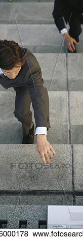 Businessmen crouching on steps reaching for laptop computer set at top of stairs View Large Photo Image Stock Photo - Businessmen crouching on steps reaching for laptop computer set at top of stairs. Fotosearch