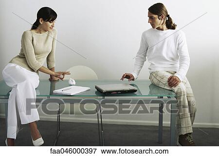 Colleagues flicking paper ball back and forth across table View Large Photo Image Stock Photo - Colleagues flicking paper ball back and forth across table. Fotosearch