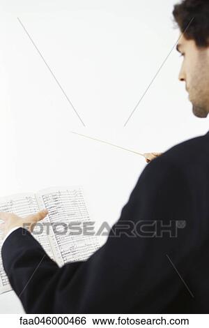 Conductor with musical score and conductor's baton View Large Photo Image Stock Photograph - Conductor with musical score and conductor's baton. Fotosearch