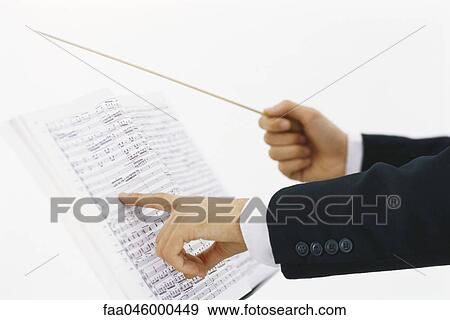 Stock Photo - Conductor's hands with conductor's baton and musical score. Fotosearch