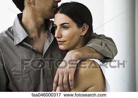 Couple embracing, woman looking away with thoughtful expression View Large Photo Image Stock Photo - Couple embracing, woman looking away with thoughtful expression. Fotosearch