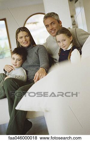 Family sitting together on sofa View Large Photo Image Stock Photo - Family sitting together on sofa. Fotosearch