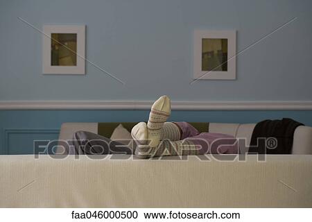 Feet resting on back of sofa, rear view View Large Photo Image Stock Image - Feet resting on back of sofa, rear view. Fotosearch