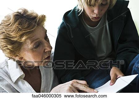 Stock Photography - Grandmother helping grandson with homework. Fotosearch