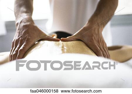 Hands of massage therapist massaging woman's back View Large Photo Image Stock Photo - Hands of massage therapist massaging woman's back. Fotosearch