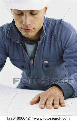 Picture - Handyman looking at blueprints. Fotosearch