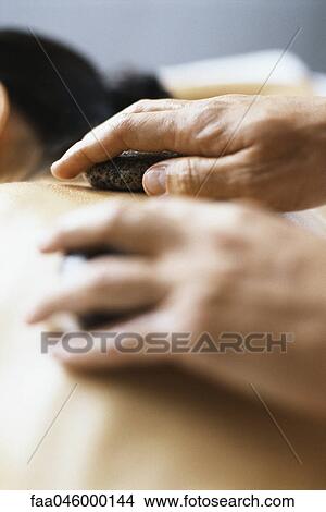 hot stone therapy, stones being positioned on patient's bare back View Large Photo Image Picture - hot stone therapy, stones being positioned on patient's bare back. Fotosearch