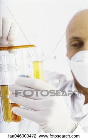 Stock Image - Laboratory technician transferring liquid to test tube. Fotosearch