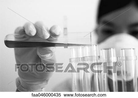 Stock Photography - Laboratory technician transferring liquid to test tube. Fotosearch