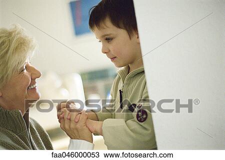 Little boy face to face with grandmother, holding hands View Large Photo Image Stock Image - Little boy face to face with grandmother, holding hands. Fotosearch