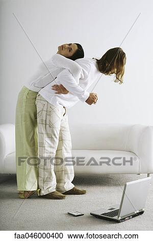 Stock Image - Man attempting and failing to lift woman on back. Fotosearch