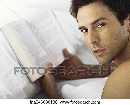 Man holding book, looking over shoulder at camera View Large Photo Image Stock Image - Man holding book, looking over shoulder at camera. Fotosearch