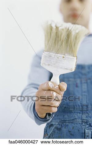 Stock Photo - Man holding up paintbrush. Fotosearch
