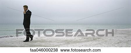 Man in suit walking on beach View Large Photo Image Stock Photo - Man in suit walking on beach. Fotosearch