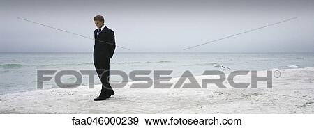 Man in suit walking on beach View Large Photo Image Stock Photo - Man in suit walking on beach. Fotosearch