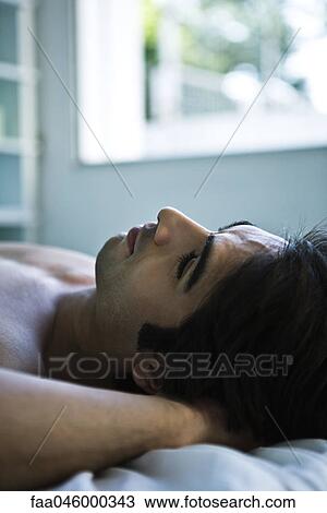 Man lying on back with hands behind head resting View Large Photo Image Stock Image - Man lying on back with hands behind head resting. Fotosearch