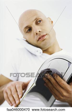 Man on phone call, reading magazine View Large Photo Image Stock Image - Man on phone call, reading magazine. Fotosearch