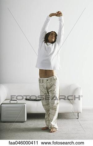 Man stretching with arms raised above head View Large Photo Image Stock Image - Man stretching with arms raised above head. Fotosearch
