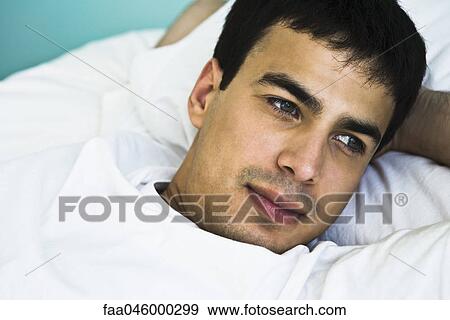 Man with arms behind head contemplatively looking away View Large Photo Image Stock Photo - Man with arms behind head contemplatively looking away. Fotosearch