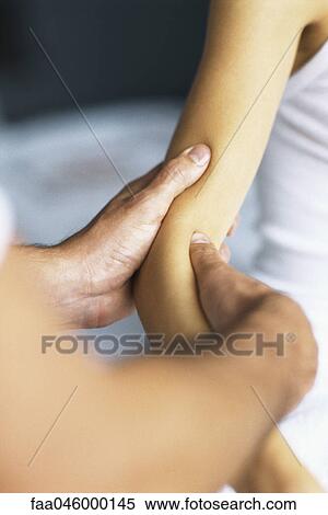 Massage therapist massaging patient's arm View Large Photo Image Stock Photography - Massage therapist massaging patient's arm. Fotosearch