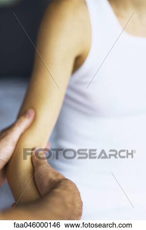 Massage therapist massaging woman's arm, cropped View Large Photo Image Stock Photograph - Massage therapist massaging woman's arm, cropped. Fotosearch