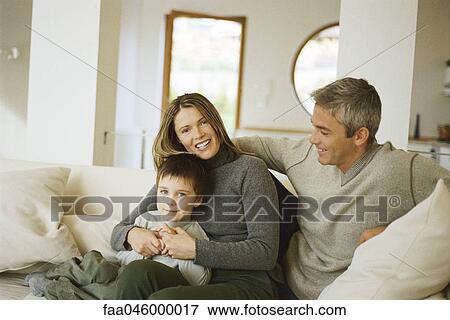 Parents sitting with young son on sofa, portrait View Large Photo Image Stock Photo - Parents sitting with young son on sofa, portrait. Fotosearch