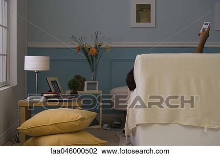 Person reclining on sofa controlling air conditioner with remote control, rear view View Large Photo Image Stock Image - Person reclining on sofa controlling air conditioner with remote control, rear view. Fotosearch