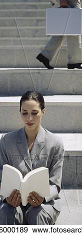 Professionally dressed woman on steps reading book View Large Photo Image Stock Photo - Professionally dressed woman on steps reading book. Fotosearch
