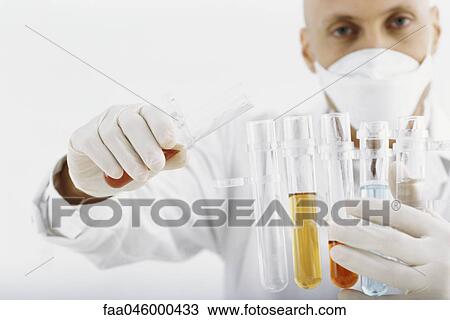 Stock Image - Researcher transferring liquid to test tube. Fotosearch