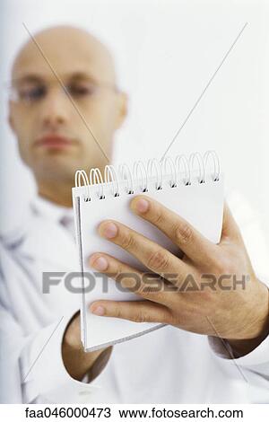 Stock Image - Researcher writing notes in notebook. Fotosearch