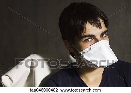 Teenage boy wearing flu mask, looking at camera View Large Photo Image Stock Image - Teenage boy wearing flu mask, looking at camera. Fotosearch