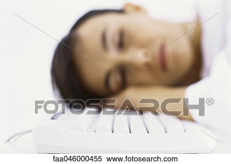 Stock Photography - Woman asleep, resting head on computer keyboard. Fotosearch