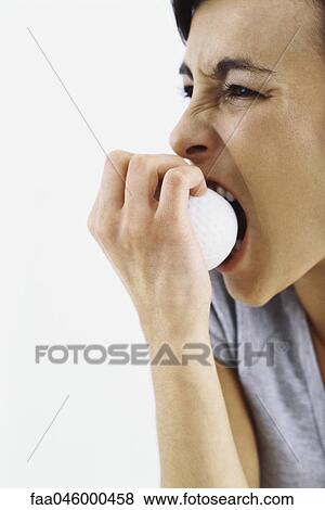 Woman biting into golf ball View Large Photo Image Stock Photo - Woman biting into golf ball. Fotosearch