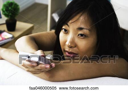 Woman changing channel with remote control View Large Photo Image Stock Photography - Woman changing channel with remote control. Fotosearch