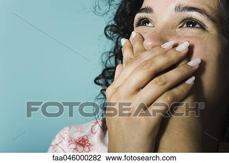 Woman covering mouth with hands, portrait View Large Photo Image Stock Image - Woman covering mouth with hands, portrait. Fotosearch