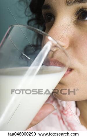 Stock Image - Woman drinking glass of milk, close-up. Fotosearch
