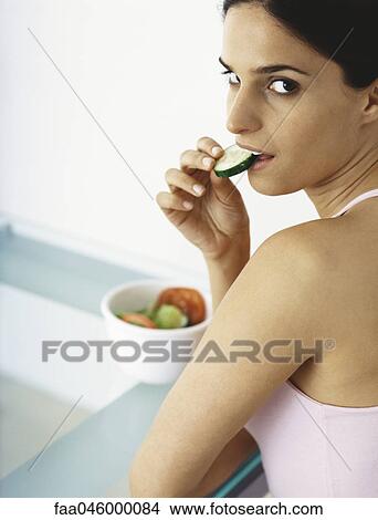 Woman eating sliced raw vegetables View Large Photo Image Picture - Woman eating sliced raw vegetables. Fotosearch
