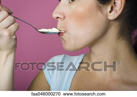 Woman eating spoon full of ice cream View Large Photo Image Stock Image - Woman eating spoon full of ice cream. Fotosearch