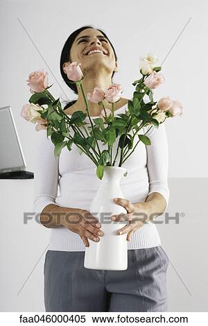 Woman holding vase of roses, smiling with head back View Large Photo Image Stock Photography - Woman holding vase of roses, smiling with head back. Fotosearch