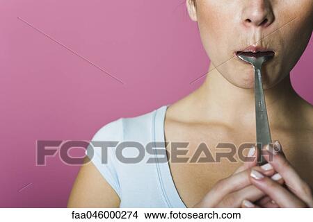 Woman licking spoon, cropped View Large Photo Image Picture - Woman licking spoon, cropped. Fotosearch