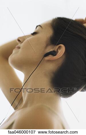 Woman listening to earphones, eyes closed View Large Photo Image Stock Photo - Woman listening to earphones, eyes closed. Fotosearch