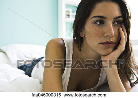 Woman lying on bed looking away contemplatively View Large Photo Image Stock Photography - Woman lying on bed looking away contemplatively. Fotosearch