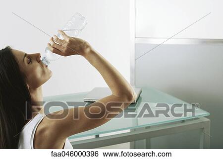 Woman quenching thirst View Large Photo Image Stock Photograph - Woman quenching thirst. Fotosearch