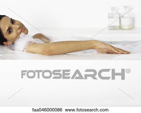 Stock Photograph - Woman relaxing in bubble bath. Fotosearch