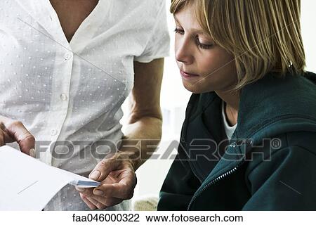 Stock Image - Woman showing boy document, cropped. Fotosearch