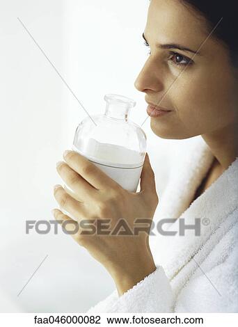 Woman smelling aroma from open bottle View Large Photo Image Stock Image - Woman smelling aroma from open bottle. Fotosearch