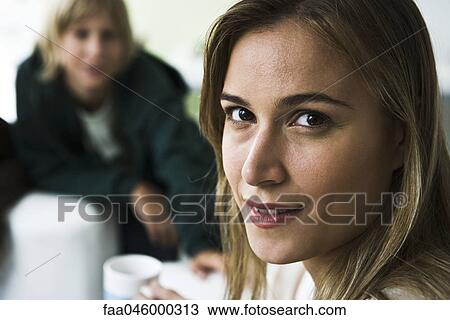 Woman smiling over shoulder at camera, boy in background View Large Photo Image Stock Image - Woman smiling over shoulder at camera, boy in background. Fotosearch